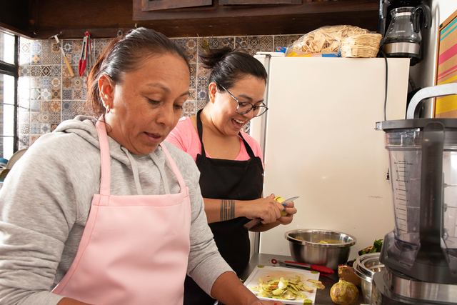 Dos cocineras picando la fruta de temporada en la cocina